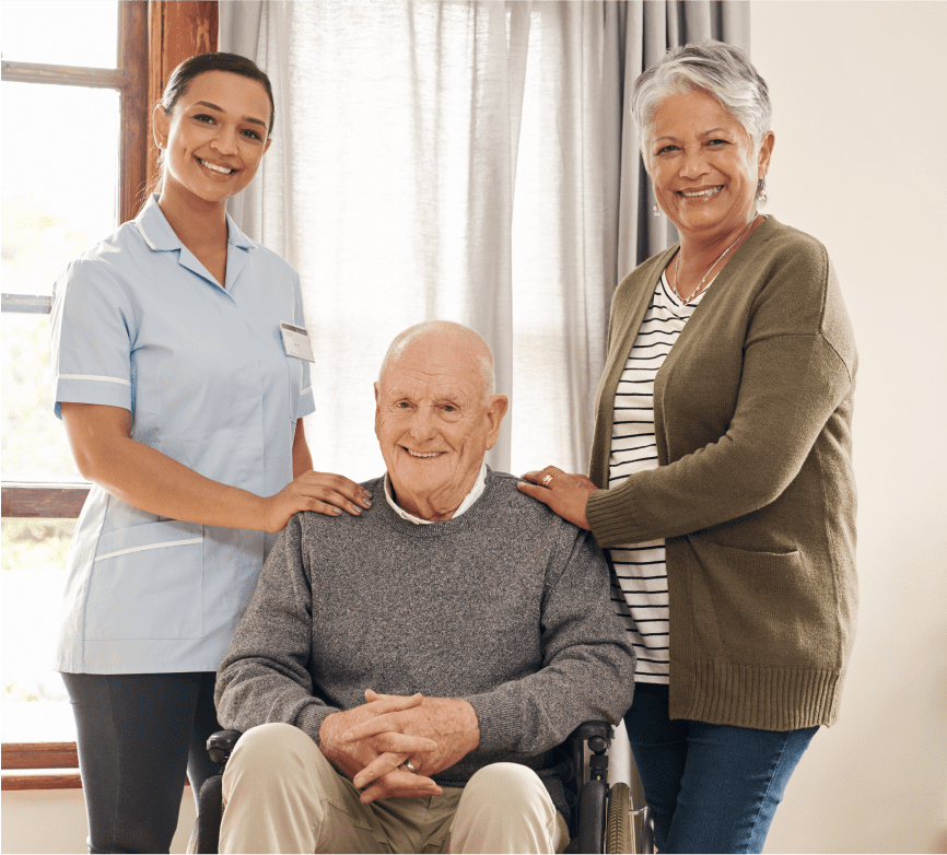Elderly man with caregiver and woman smiling.