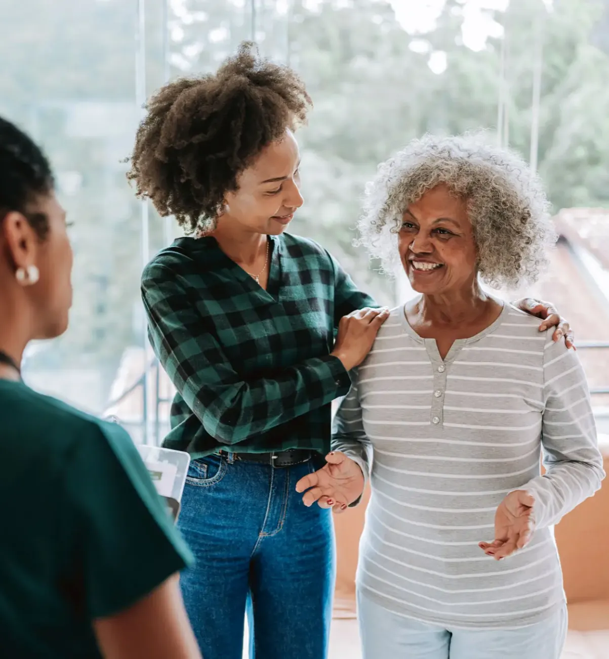 Young woman affectionately touching elderly woman's hair in a warm moment.